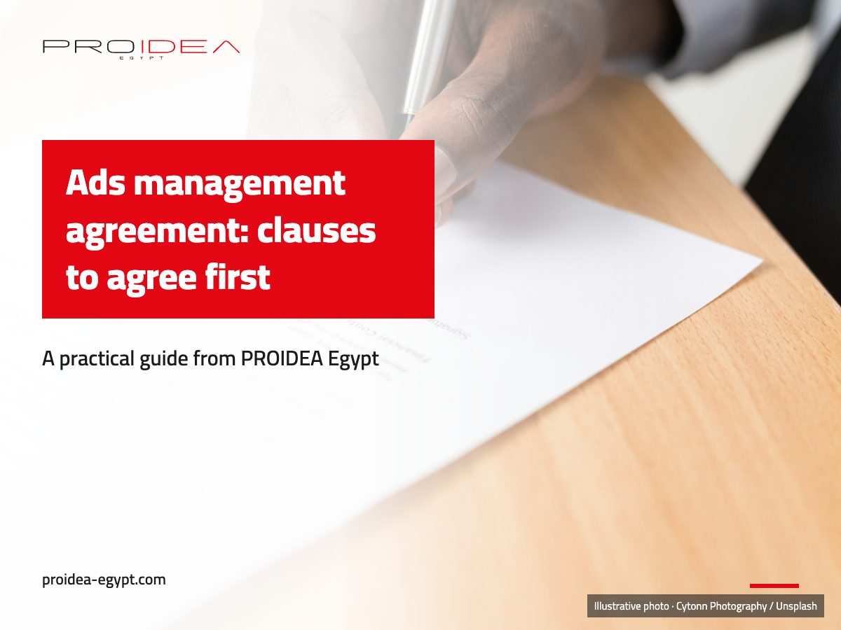 Illustration for “Ads management agreement”: A hand signing a paper contract on a wooden desk