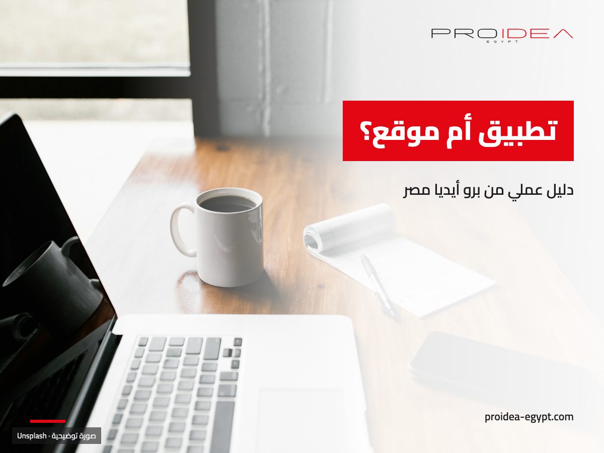 صورة توضيحية لمقال «تطبيق أم موقع»: لابتوب وموبايل وفنجان قهوة على مكتب خشبي